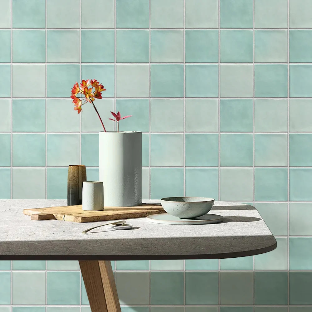 Teal tiled wall with a table and decorative items