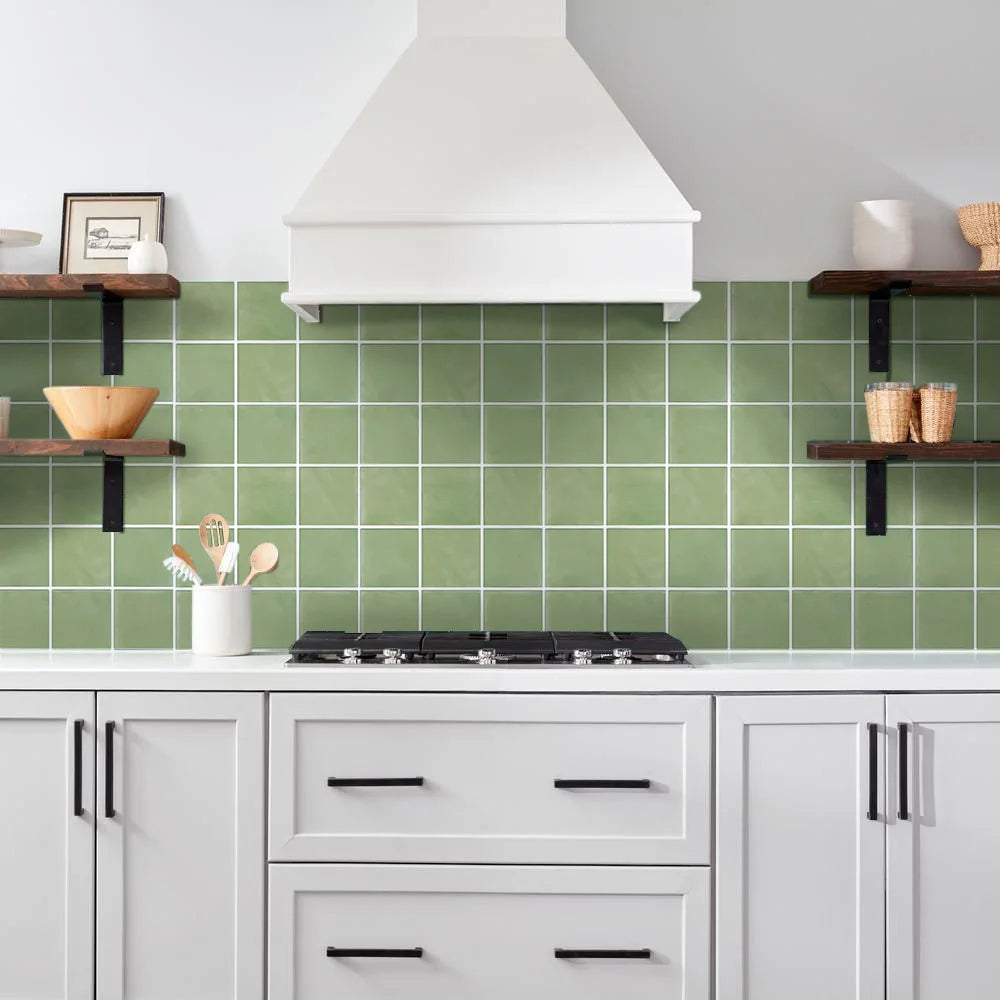 Kitchen with green tiled backsplash and white cabinets